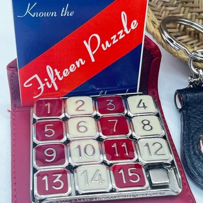 LOT 121: Pewter Nantucket Scrimshaw Basket Pendant, Dyed Oval Howlite Pendant, Two Art Glass Pendants, Fifteen Puzzle and More!