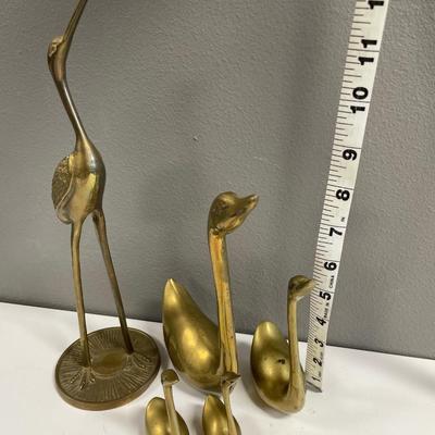 Brass swans and crane with heads looking up