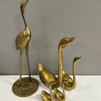 Brass swans and crane with heads looking up