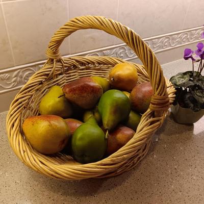 A BASKET OF REALISTIC FRUIT, CUTTING BOARD AND A FAUX FLOWER