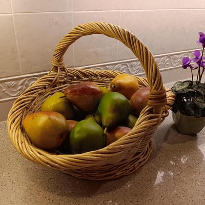 A BASKET OF REALISTIC FRUIT, CUTTING BOARD AND A FAUX FLOWER