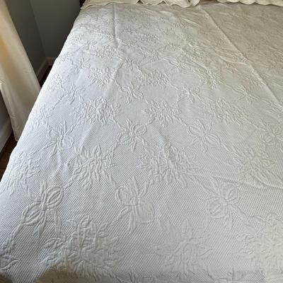 Queen size white detailed quilt, bed skirt and two shams.