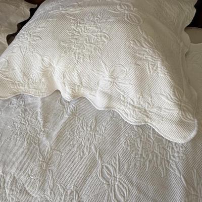 Queen size white detailed quilt, bed skirt and two shams.