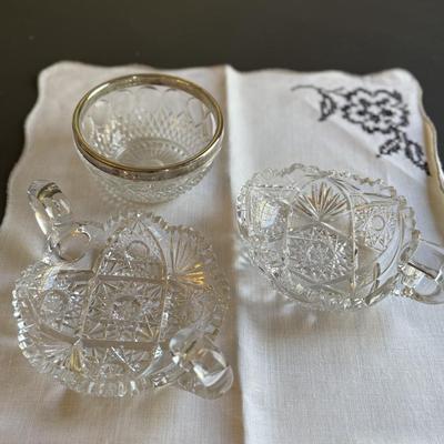 Two cut glass candy dishes with handles and silver rimmed bowl