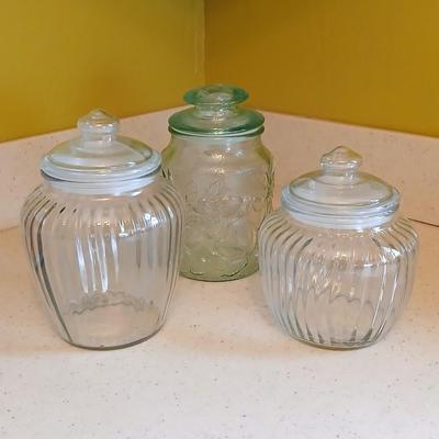 Three glass storage jars / canisters with lids