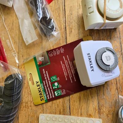 Assortment of homehardware - timers - zip ties - floor pads for furniture legs - and more