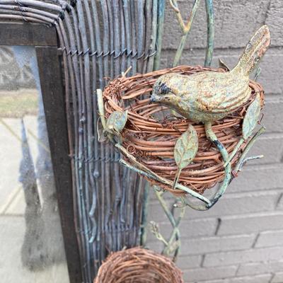 Rustic woven effect framed mirror with bird nest feature on frame.