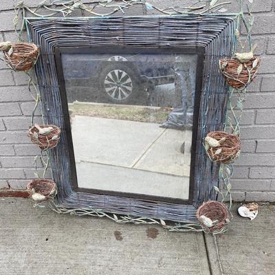 Rustic woven effect framed mirror with bird nest feature on frame.