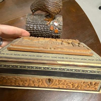 Wood carved bird and box filled with chess pieces
