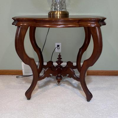 ANTIQUE PARLOR TABLE ON CASTERS AND A HEAVY CRYSTAL CUT LAMP