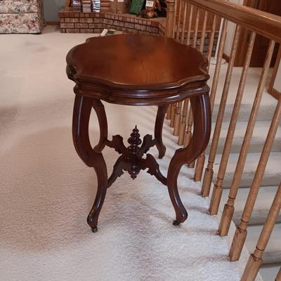 ANTIQUE PARLOR TABLE ON CASTERS AND A HEAVY CRYSTAL CUT LAMP