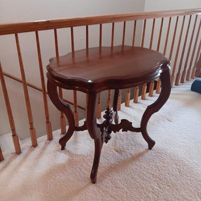 ANTIQUE PARLOR TABLE ON CASTERS AND A HEAVY CRYSTAL CUT LAMP