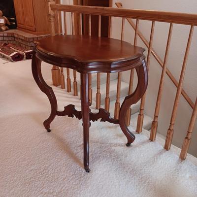ANTIQUE PARLOR TABLE ON CASTERS AND A HEAVY CRYSTAL CUT LAMP