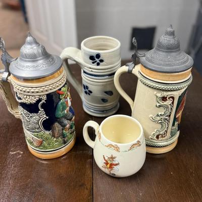 Two steins and two miscellaneous mugs