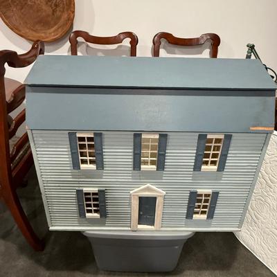 Vintage dollhouse and bin of accessories and furniture.