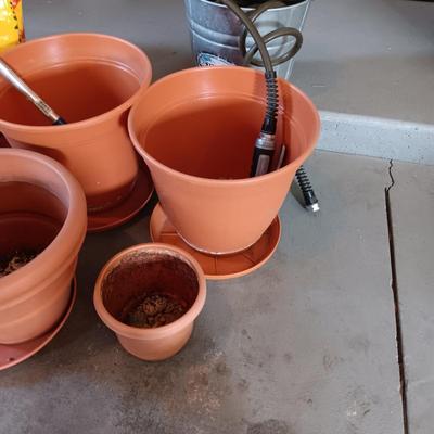 FLOWER POTS, GARDEN HOSE W/SPRAYER, PARTIAL BAG OF SOIL AND MORE