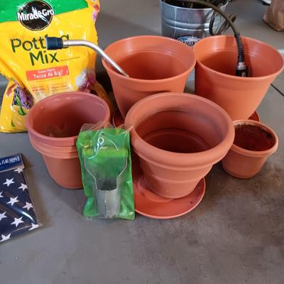 FLOWER POTS, GARDEN HOSE W/SPRAYER, PARTIAL BAG OF SOIL AND MORE