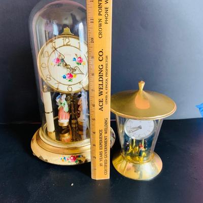 LOT 309: German Kern Anniversary Clock with Enamel Face and Base with Porcelain Figures and Vintage 8 Day Clock with German Figures on...