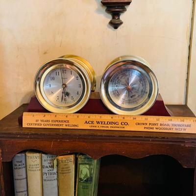 LOT 667: Bookcase with Classic Books, Mantle Weather Station, Side Table with Shelf and Anniversary Clock