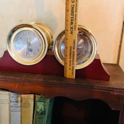 LOT 667: Bookcase with Classic Books, Mantle Weather Station, Side Table with Shelf and Anniversary Clock