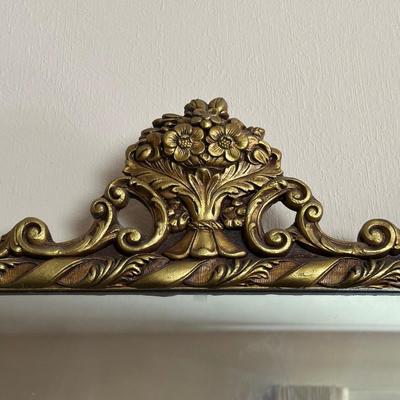 WALL MIRROR WITH AN ORNATE FRAME