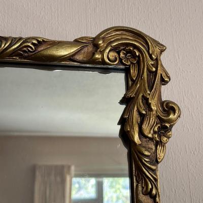 WALL MIRROR WITH AN ORNATE FRAME