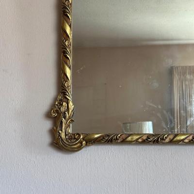 WALL MIRROR WITH AN ORNATE FRAME