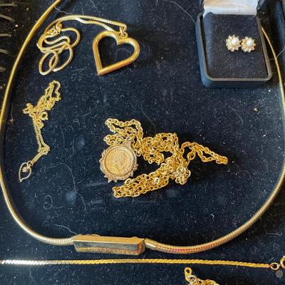 Black necklace holder with gold tone jewelry