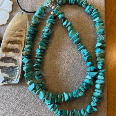 Wood, shell necklaces and a polished rock