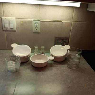 5 CORNING WARE DISHES WITH HANDLES, GLASS SHAKERS, RAMEKINS AND A GLASS CUTTING BOARD