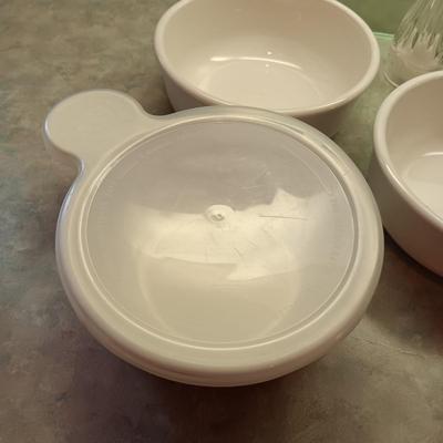 5 CORNING WARE DISHES WITH HANDLES, GLASS SHAKERS, RAMEKINS AND A GLASS CUTTING BOARD