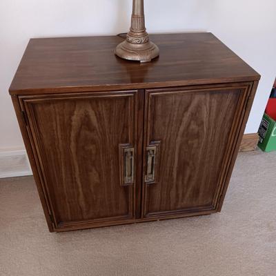 2 DOOR CABINET FILLED WITH PLACEMATS AND A LAMP WITH A DIMMER SWITCH