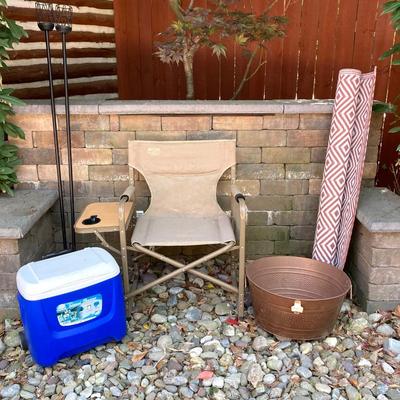 LOT 115: Outdoor Livin’ Includes and Lewis & Clark Fold & Go Directors Chair, Tiki Torches, Cooler, Copper Plated Bottle Holder...
