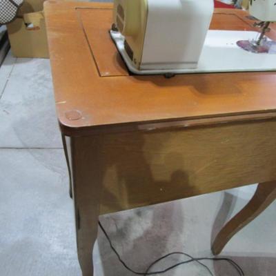 Vintage White metal sewing machine in cabinet