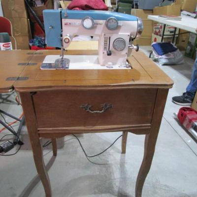 Vintage White metal sewing machine in cabinet