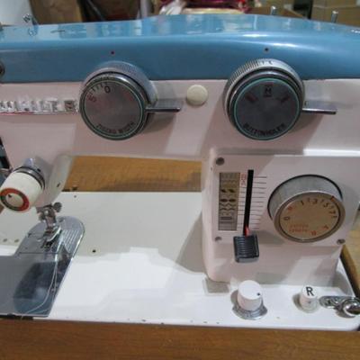 Vintage White metal sewing machine in cabinet