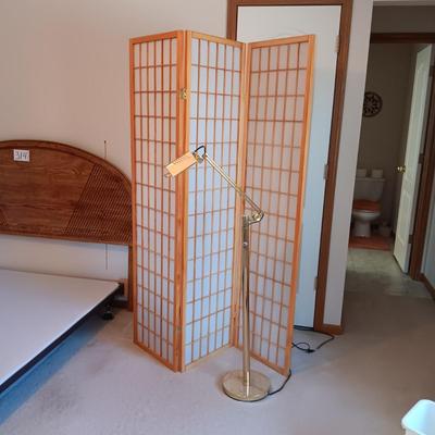 A ROOM SCREEN AND AN ADJUSTABLE BRASS COLORED FLOOR LAMP
