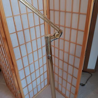 A ROOM SCREEN AND AN ADJUSTABLE BRASS COLORED FLOOR LAMP