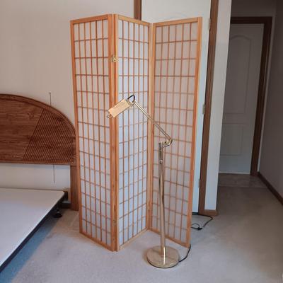A ROOM SCREEN AND AN ADJUSTABLE BRASS COLORED FLOOR LAMP