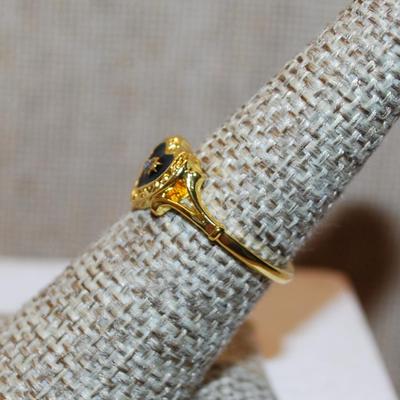 Size 8 Single Small Clear Center Stone Ring in a Black & Gold Heart Setting and Gold Tone Band (2.4g)