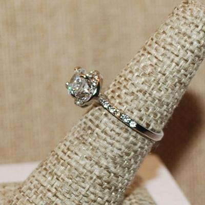 Size 6 Single Round Clear Main Stone with Side Accents & Set on a Circle Setting on a Silver Tone Band (2.6g)