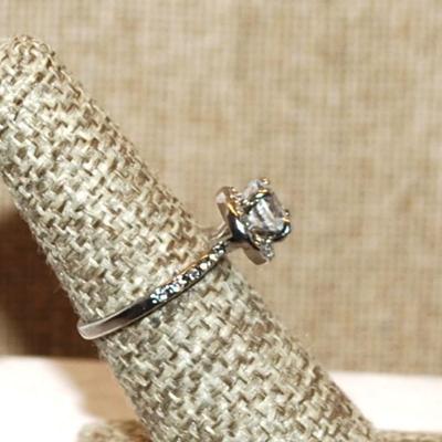 Size 6 Single Round Clear Main Stone with Side Accents & Set on a Circle Setting on a Silver Tone Band (2.6g)