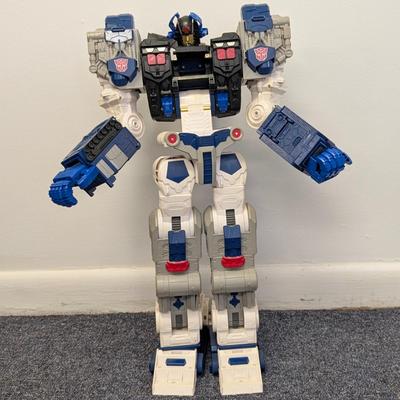 LOT 108: Transformers Generations Legacy Titan Cybertron & A Large Assortment Of Other Transformer Action Figures.