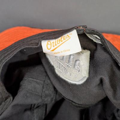 LOT 228: Baltimore Oriole Gear, Button Down Shortsleeve Shirt, Pullover, Sweatshirt, 2 Straw Hats, One Signed & 3 Baseball Caps. No...