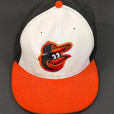 LOT 228: Baltimore Oriole Gear, Button Down Shortsleeve Shirt, Pullover, Sweatshirt, 2 Straw Hats, One Signed & 3 Baseball Caps. No...