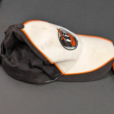 LOT 228: Baltimore Oriole Gear, Button Down Shortsleeve Shirt, Pullover, Sweatshirt, 2 Straw Hats, One Signed & 3 Baseball Caps. No...