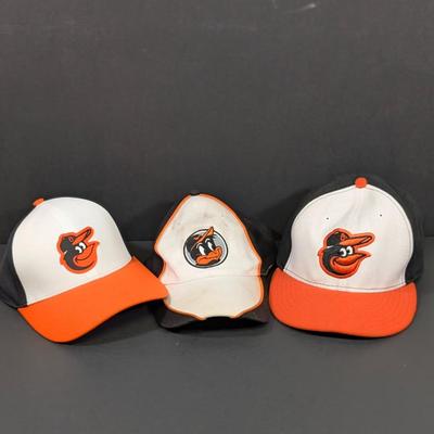 LOT 228: Baltimore Oriole Gear, Button Down Shortsleeve Shirt, Pullover, Sweatshirt, 2 Straw Hats, One Signed & 3 Baseball Caps. No...