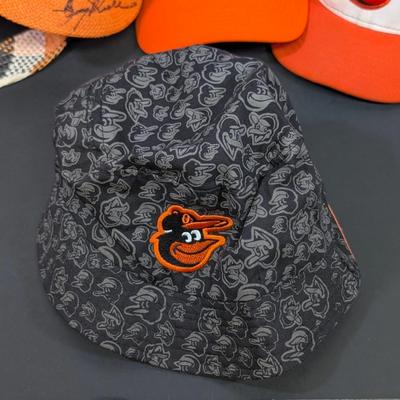 LOT 228: Baltimore Oriole Gear, Button Down Shortsleeve Shirt, Pullover, Sweatshirt, 2 Straw Hats, One Signed & 3 Baseball Caps. No...