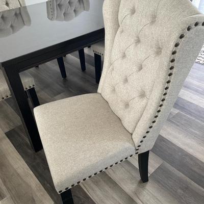 Sale Photo Thumbnail #24: Beautiful and classy dark wood table 
6 highback soft fabric with studded sides
Dimensions are 72” long x 42” wide by 30” tall. Has a plastic cover over the table to protect it and is included along with the decorations on the table.
From Ashley Fur