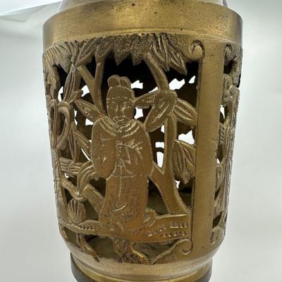 Sale Photo Thumbnail #429: Vintage Chinese brass incense burner stand. This intricately cast and pierced piece features four panels of raised figural scenes, likely depicting scholars or deities in a lush landscape, complete with traditional robes and symbolic foliage. The stem is 